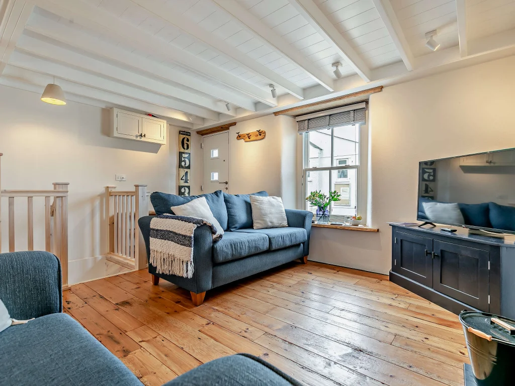 Lounge with blue sofas and white beamed ceiling