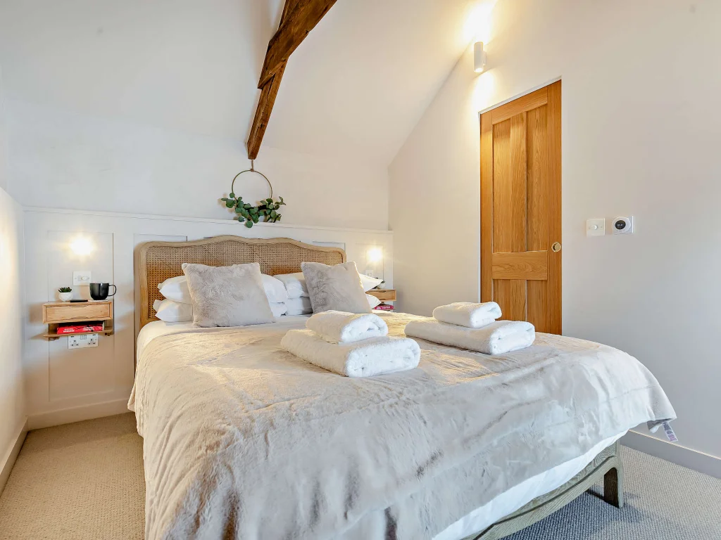 King-size bedroom with rattan headboard and vaulted ceiling