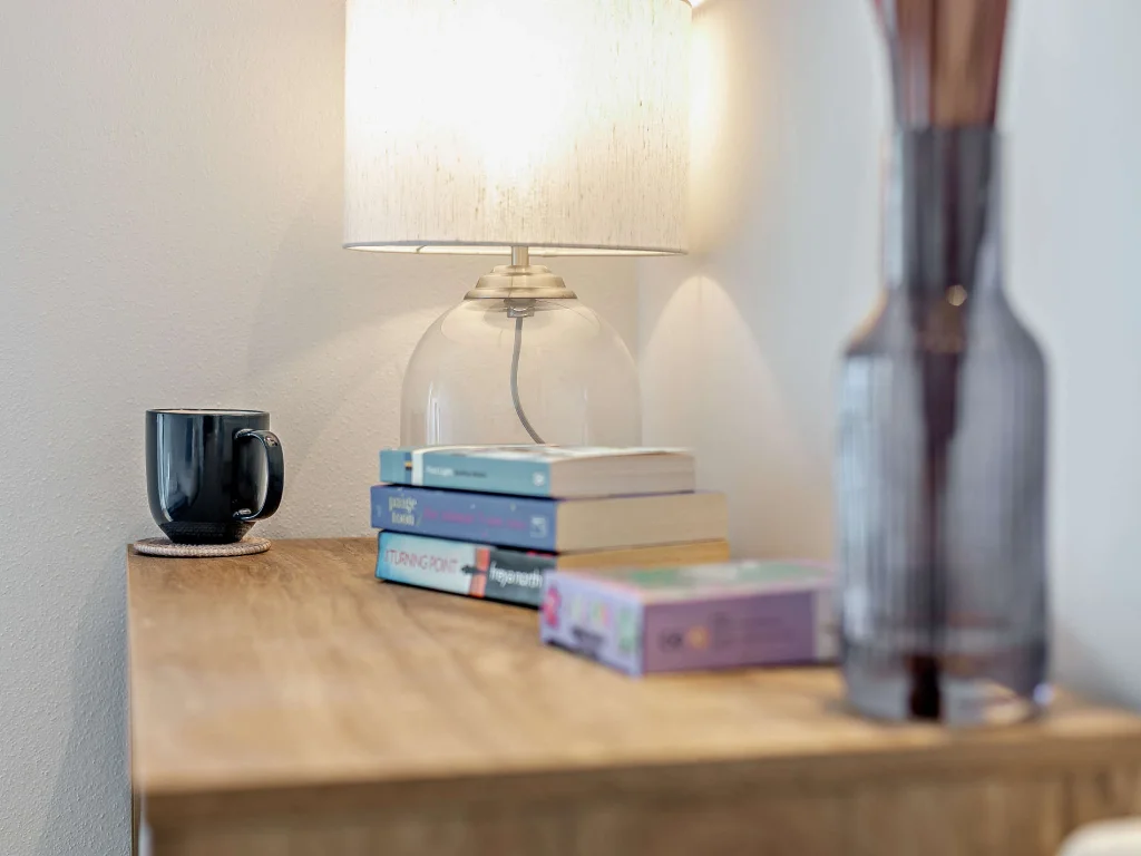Bedside lamp, books and glass vase in the bedroom