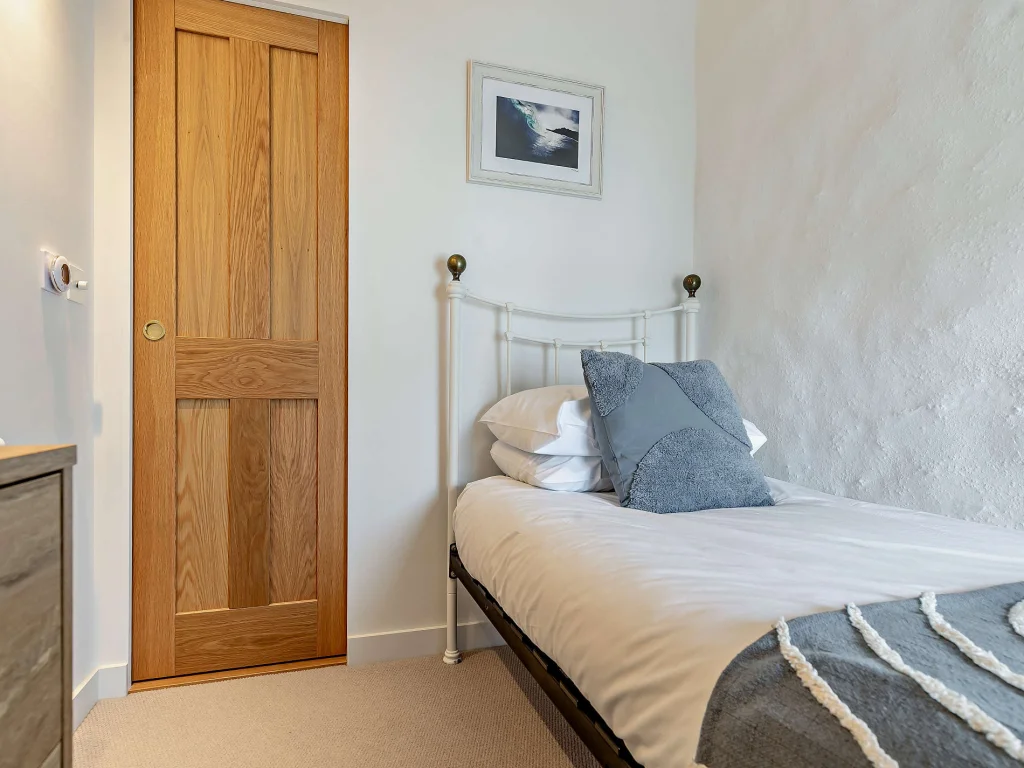 Single bedroom with coastal artwork above the bed