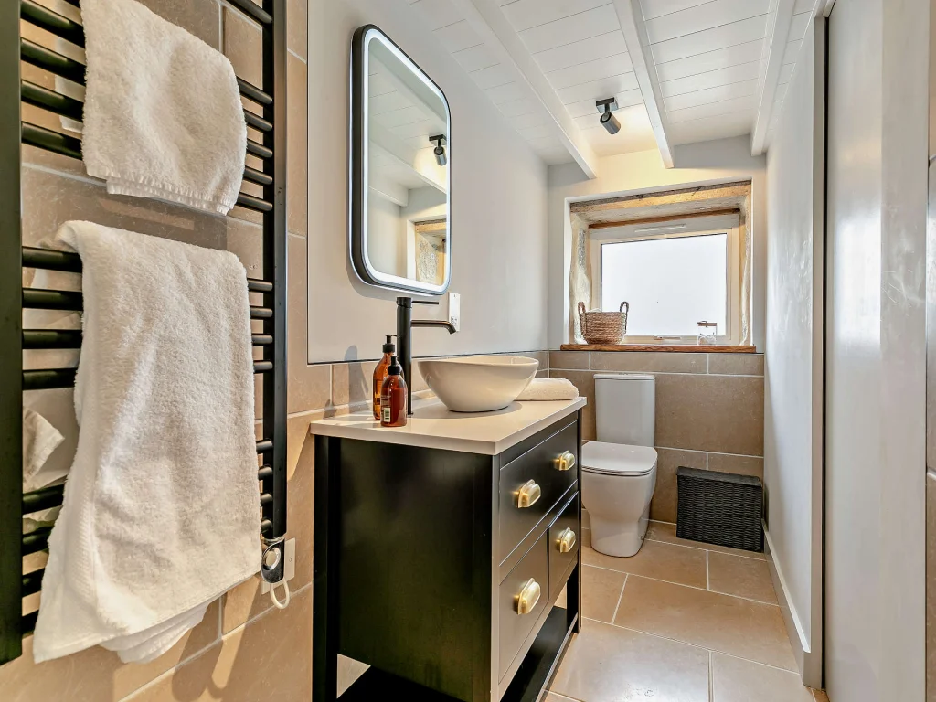 Bathroom vanity, toilet and window with stone surround